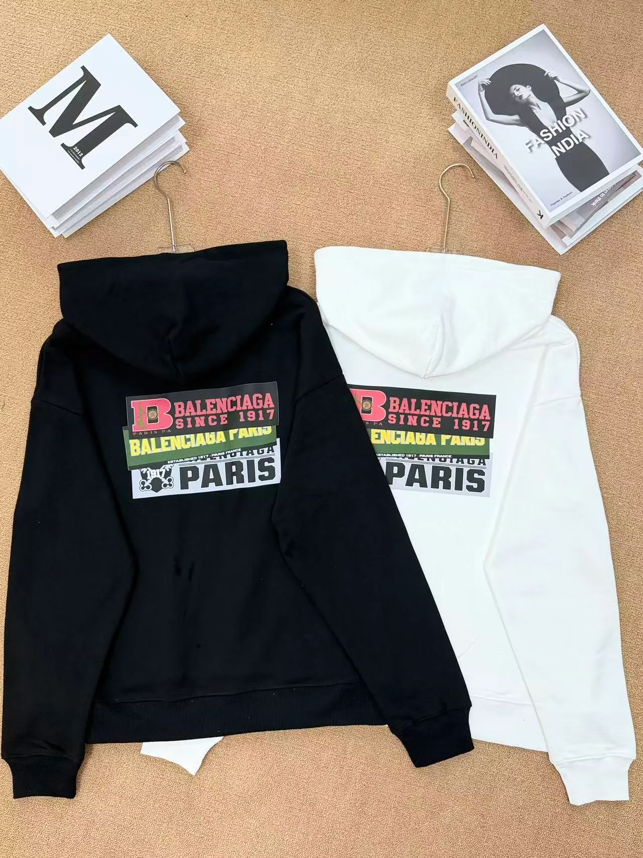 Style No. 2202 • Color: Black / White available • Version: Loose shoulder oversize version, regardless of figure, same style for men and women • Style: Pullover hooded sweatshirt, front kangaroo pocket, casual Versatile 🧶Fabric technology: Made of 420 high-gram weight cotton terry fabric, soft and thick to the touch, comfortable and Breathable on the upper body; threaded cuffs + hem, not easy to deform after long-term wear. The printing adopts high-definition offset printing, multi-layer label sticker style pattern, the color is full and firm, and the large pattern on the back has strong visual impact. 🎨Design highlights: Retro collage label printing, multi-layer BALENCIAGA letter logo superimposed, full of street fashion sense. Simple hooded basic version + exaggerated back print, low-key and recognizable, with a high-end and lazy atmosphere. 🧥Wearing scenarios: Suitable for daily commuting, shopping and outings, and campus wear. The lower body can be worn with jeans, sports pants, or shark pants. The loose fit hides the flesh and makes you look slimmer. It is perfect for couples. Sizes m l xl